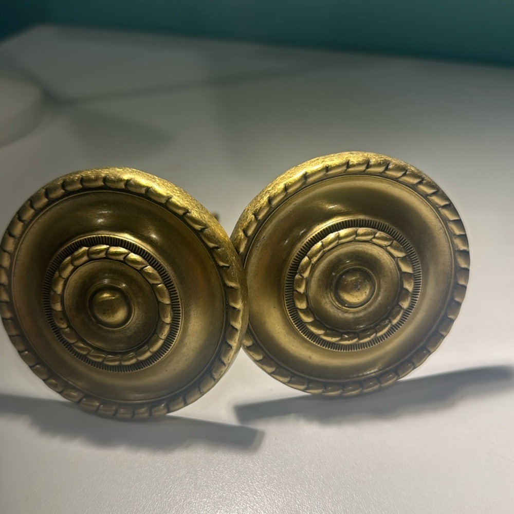 Two brass round curtain holders